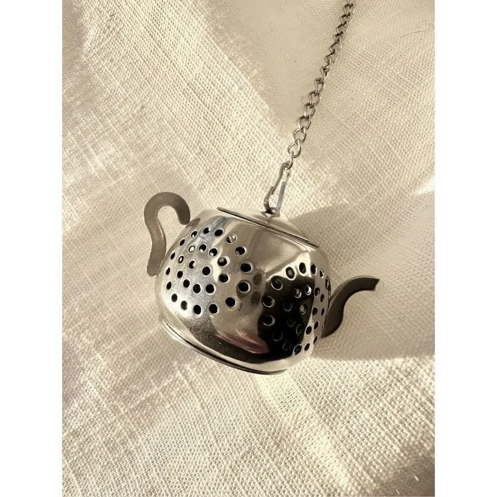 Silver colored teapot, tea diffuser
